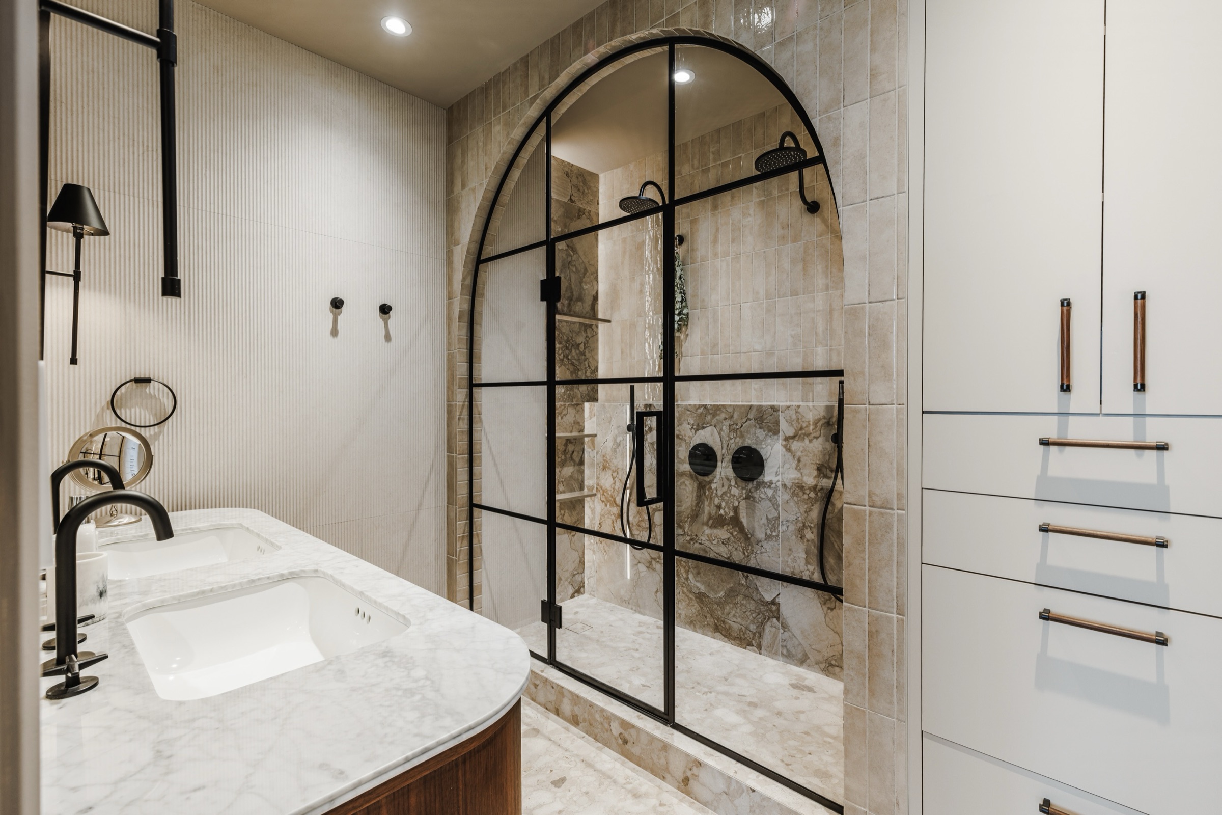 Salle de bain des maîtres, vue d'ensemble avec vanité et accès vers la douche