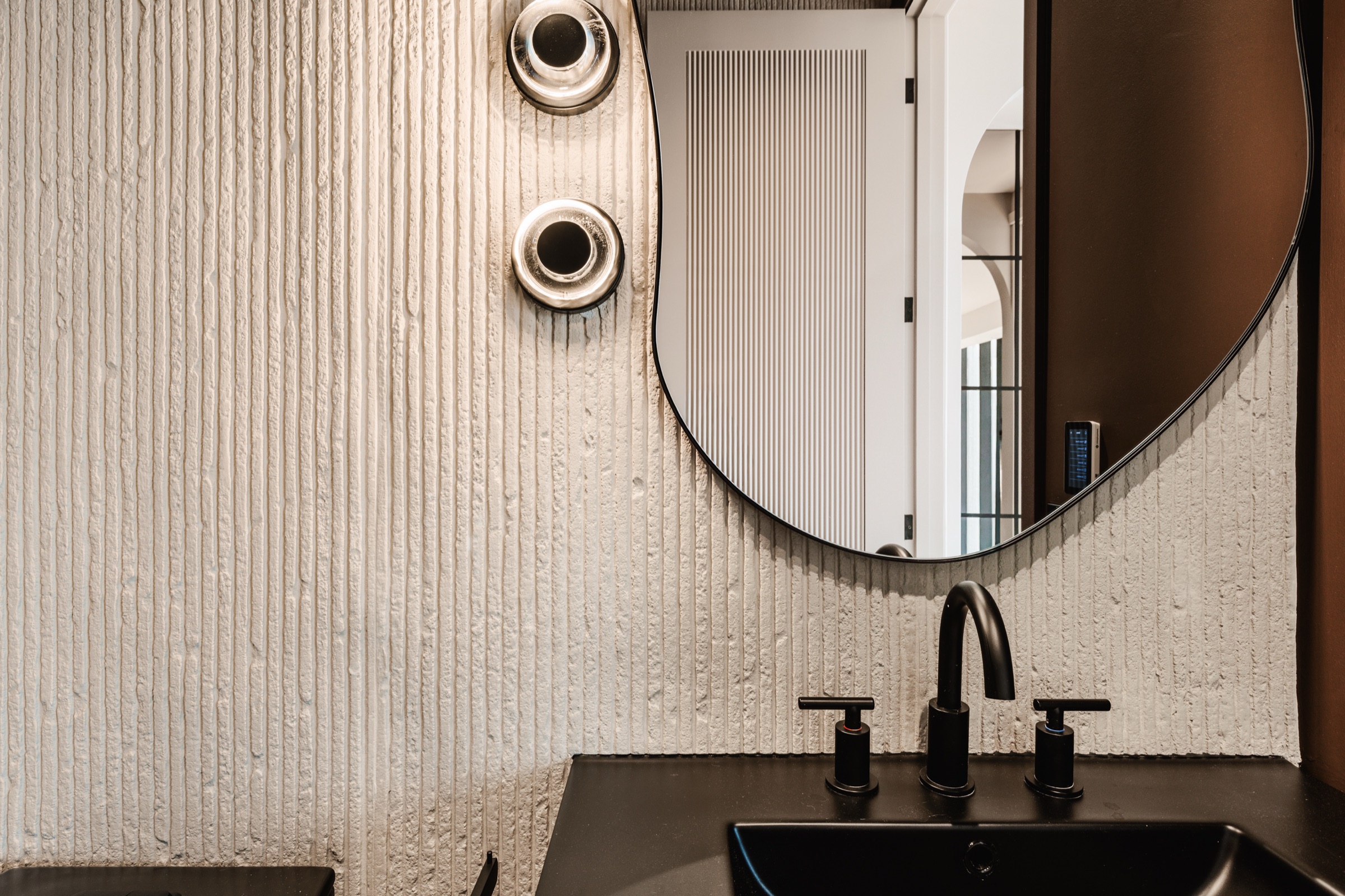 Salle de bain d'invités, détail de la vanité noire et de la robinetterie