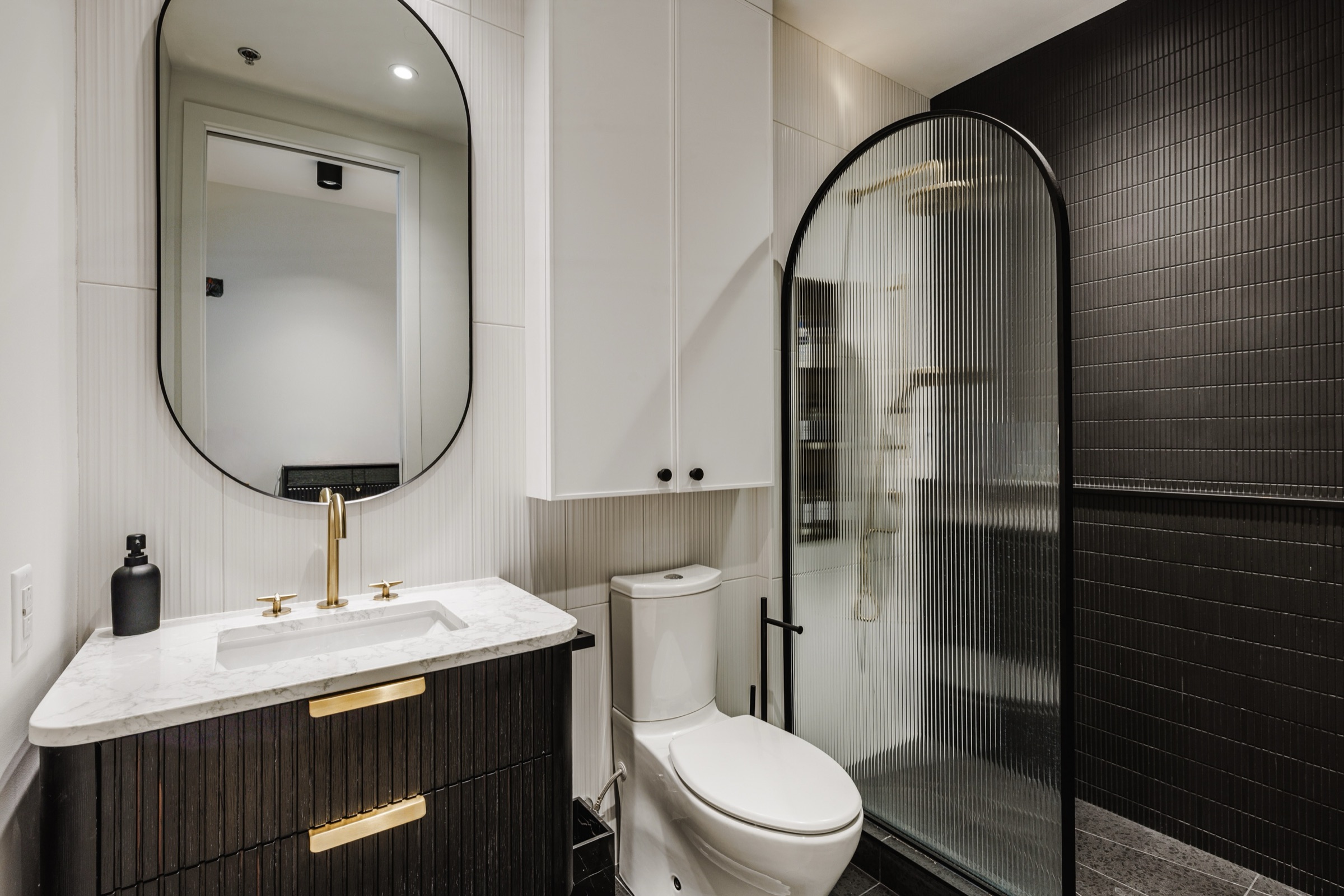 Salle de bain de la deuxième chambre, vanité noire et douche en verre cannelé